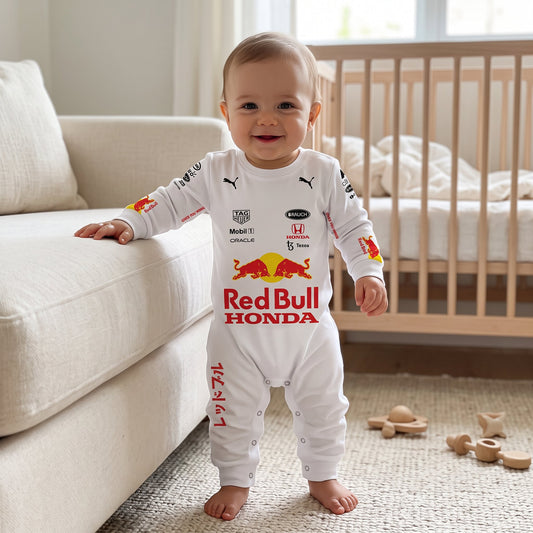 Baby standing in nursery wearing white Red Bull Honda F1 baby onesie jumpsuit with team sponsor logos