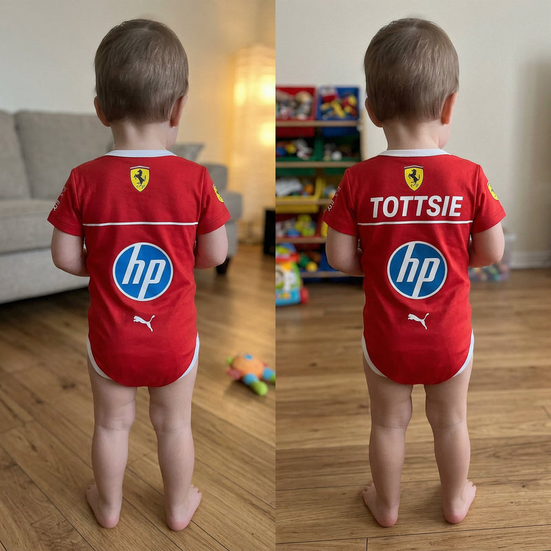 Toddler wearing red Ferrari F1 baby onesie with HP sponsor logo and custom Tottsie name on back standing on wooden floor