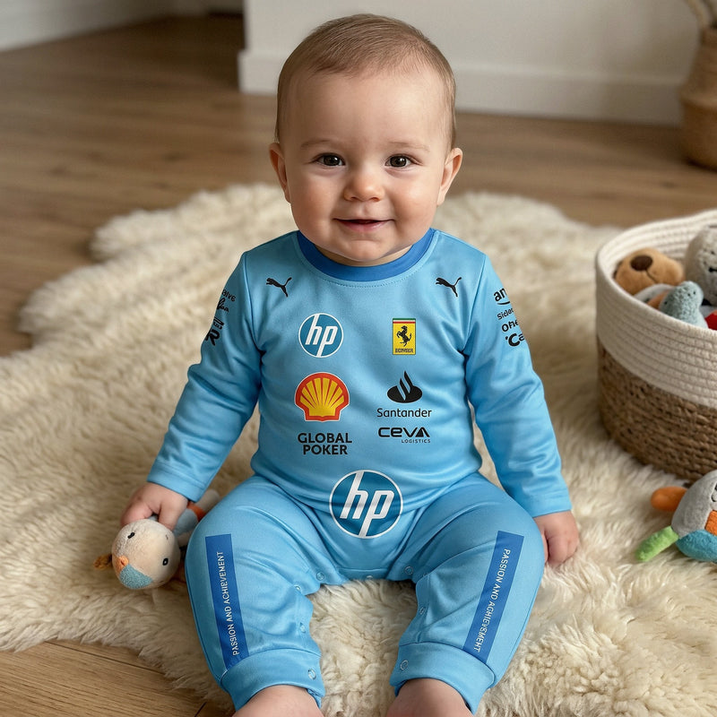 Smiling baby on a white rug wearing a light blue Ferrari F1 racing suit onesie with sponsor logos and prancing horse shield