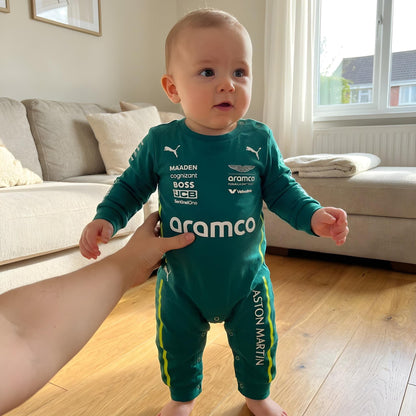 baby wearing aston martin formula one themed onesie with parent