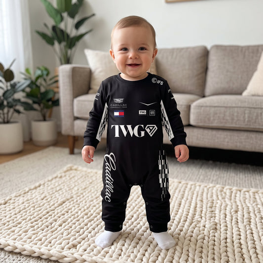 Smiling baby wearing Cadillac 2026 F1 team onesie jumpsuit standing on rug in living room