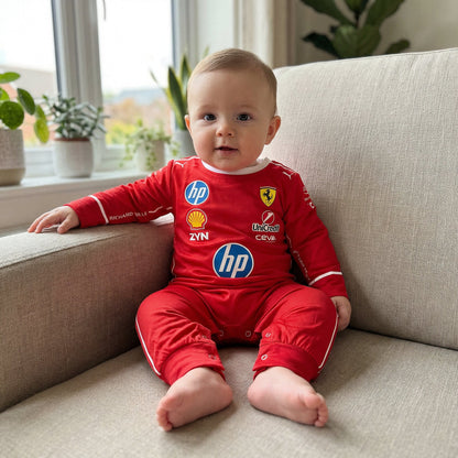 baby sitting on couch wearing ferrari baby onesie