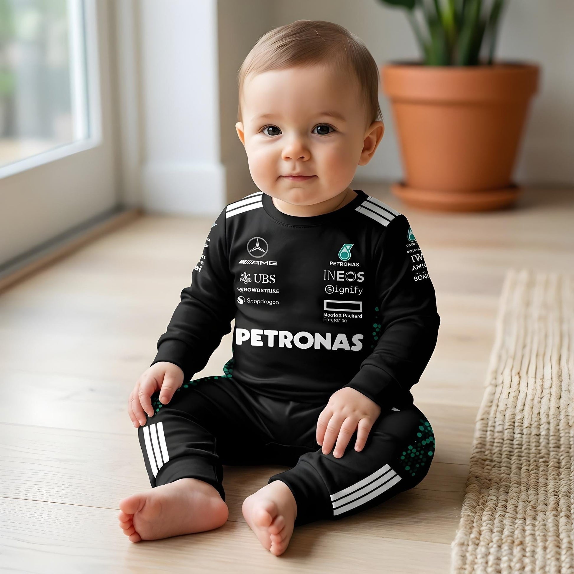 baby wearing mercedes amg baby onesie sitting on floor