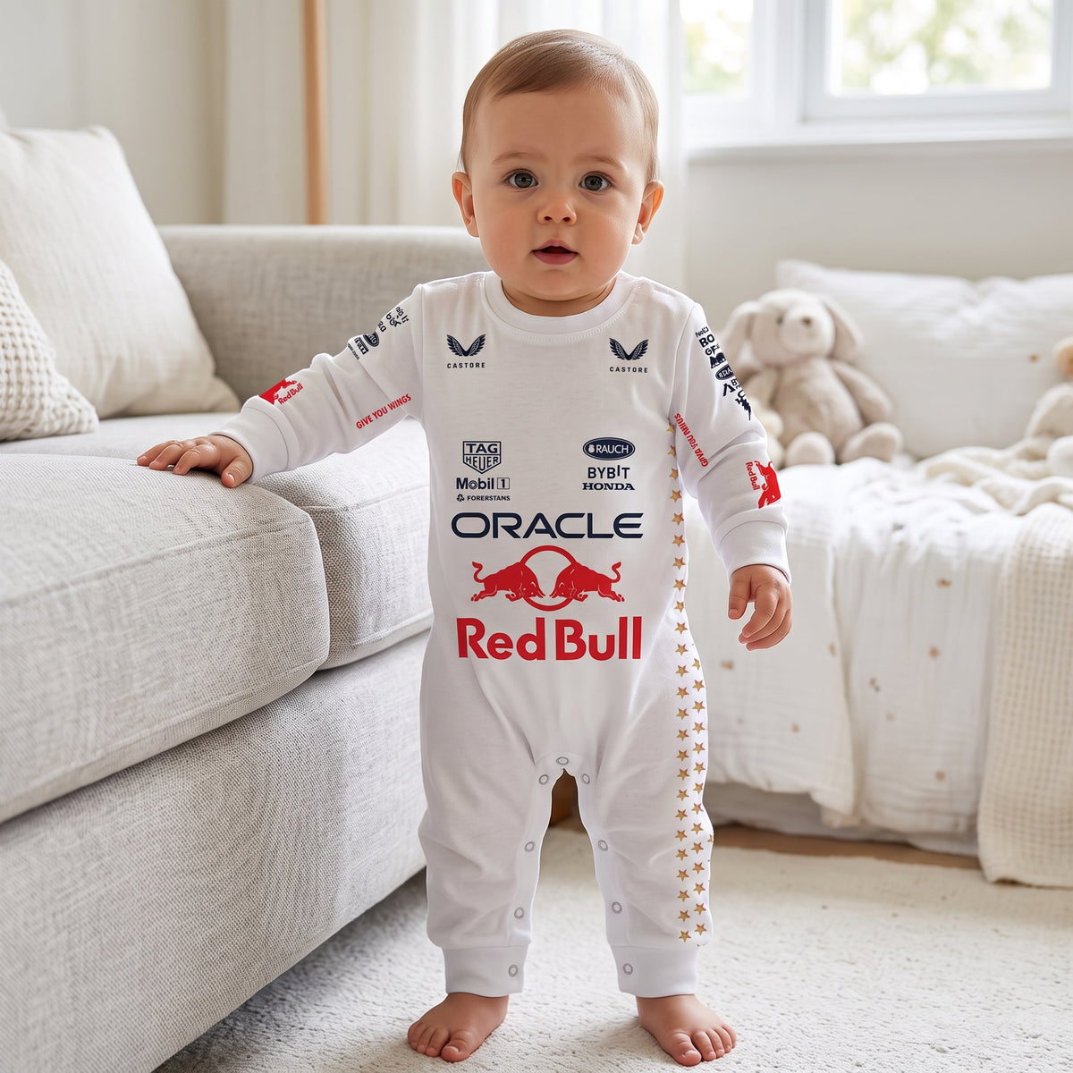 Baby standing wearing white Red Bull Las Vegas F1 onesie with Oracle logo and gold star stripe