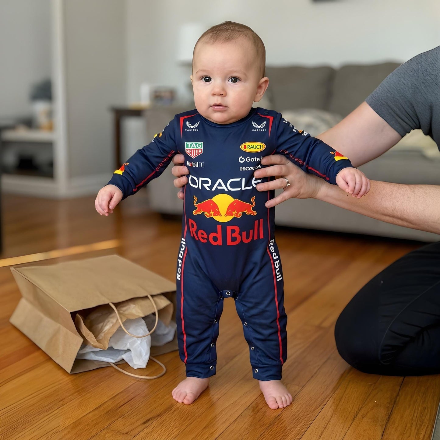 toddler taking first steps in Red Bull Racing bodysuit