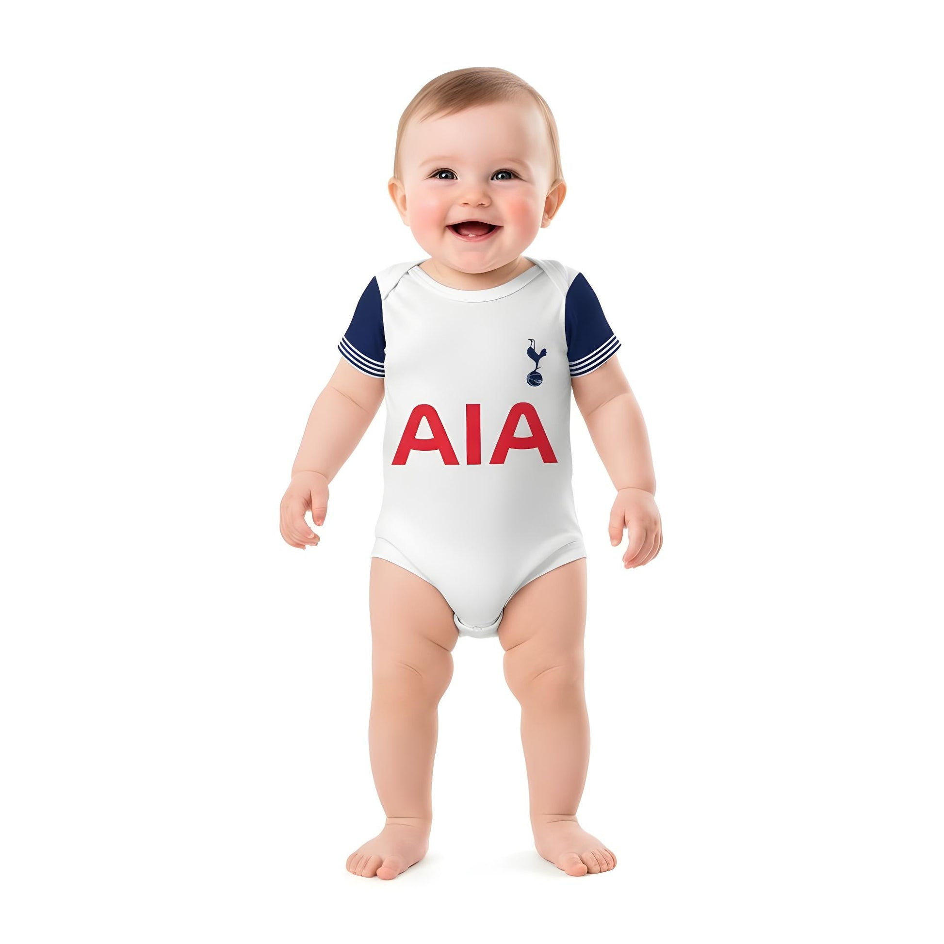 baby standing up and wearing a tottenham spurs baby onesie on white backdrop